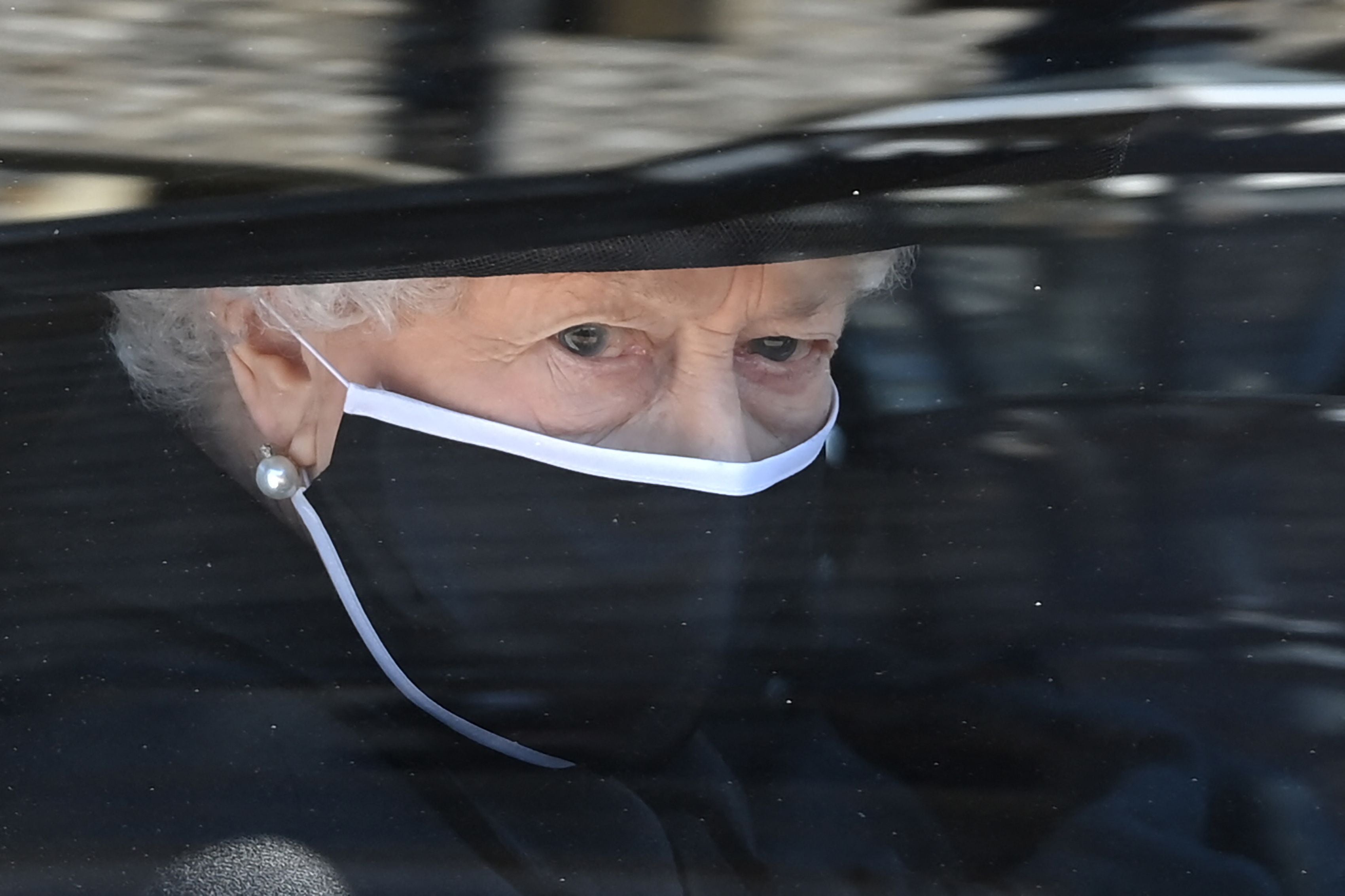 Isabel II, con mascarilla por la pandemia del coronavirus, a su llegada a la capilla de San Jorge en el castillo de Windsor, para asistir al funeral de su esposo, el duque de Edimburgo Felipe, el 17 de abril de 2021.