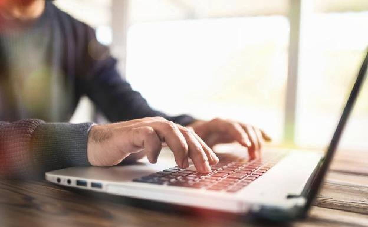 Un hombre utiliza un ordenador. 