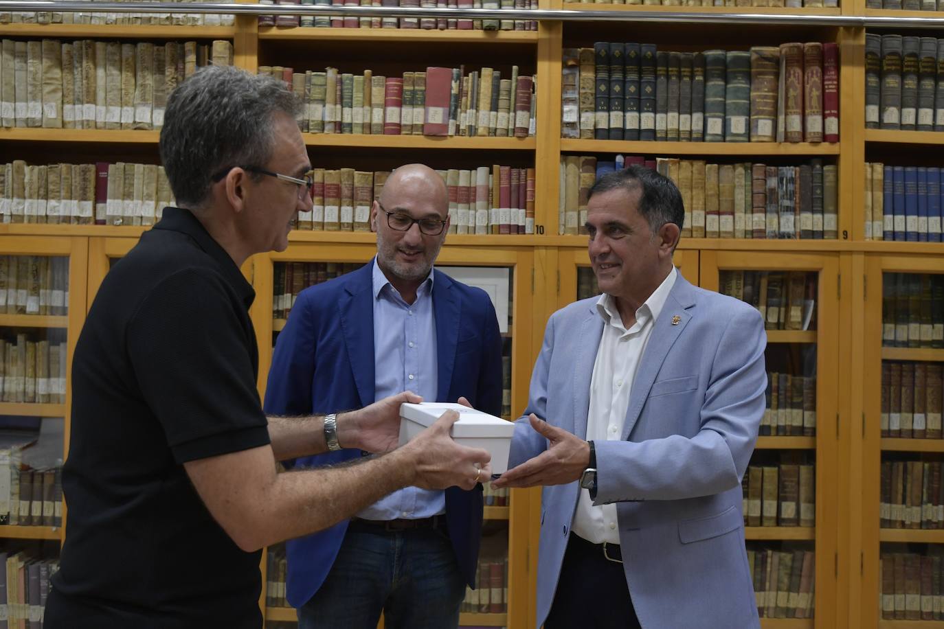 Fernando Vázquez Casillas entrega al alcalde Serrano, ante Pedro García Rex, los documentos para el Archivo Municipal.