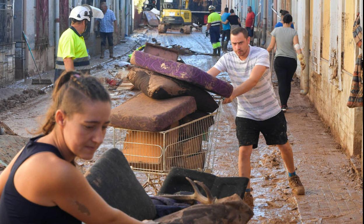 Vecinos de la localidad recogen enseres de sus viviendas tras las lluvias. 