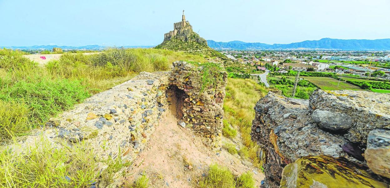 Estado que presentaban ayer los restos arqueológicos del Castillejo de Monteagudo, llenos de maleza, con el Cristo al fondo. 