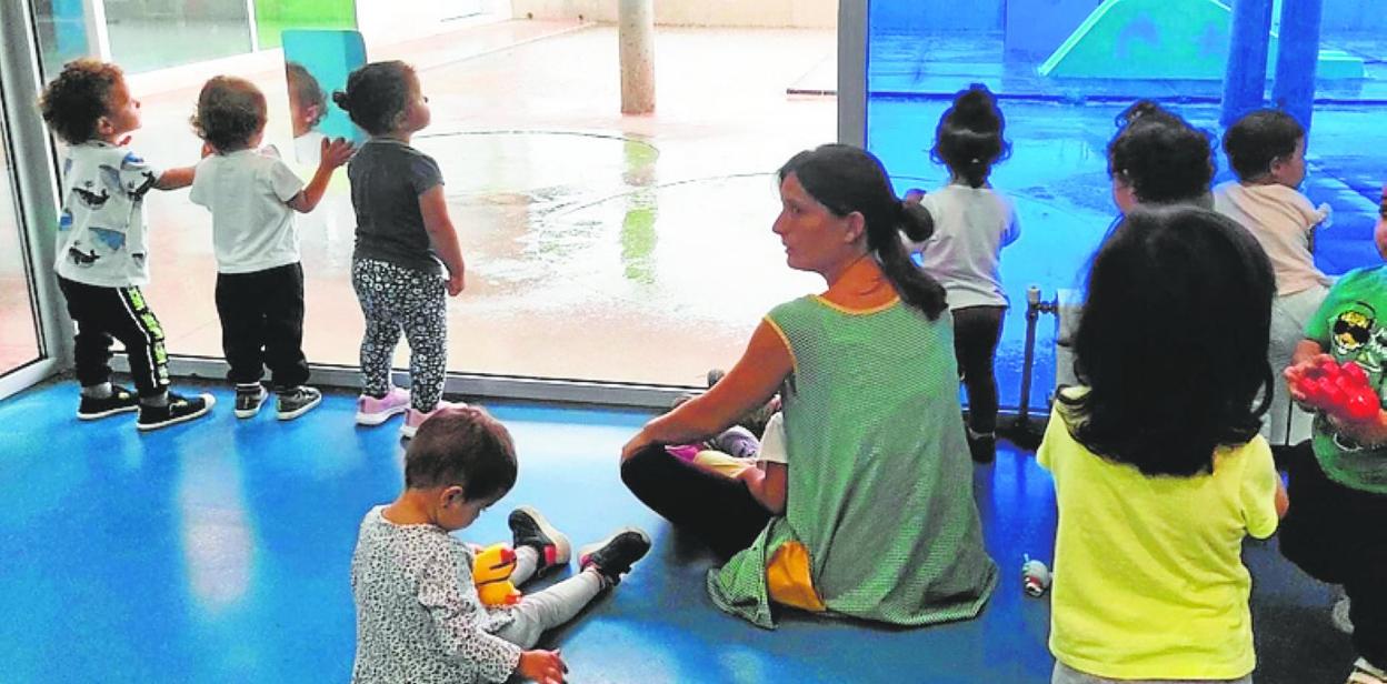 Una profesora, con algunos alumnos del centro educativo. 