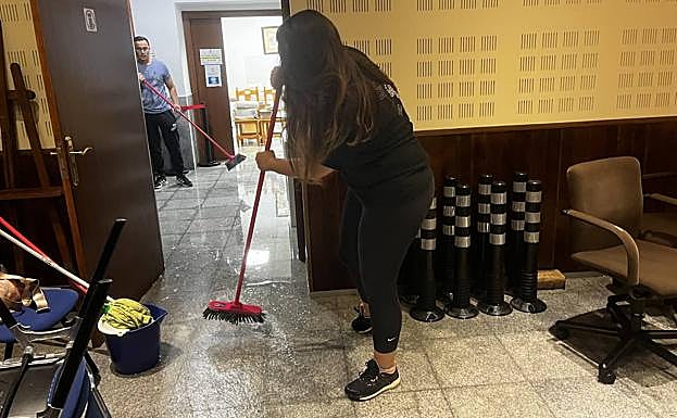 Varias personas intentan sacar agua del interior del edificio del Ayuntamiento de Ojós.