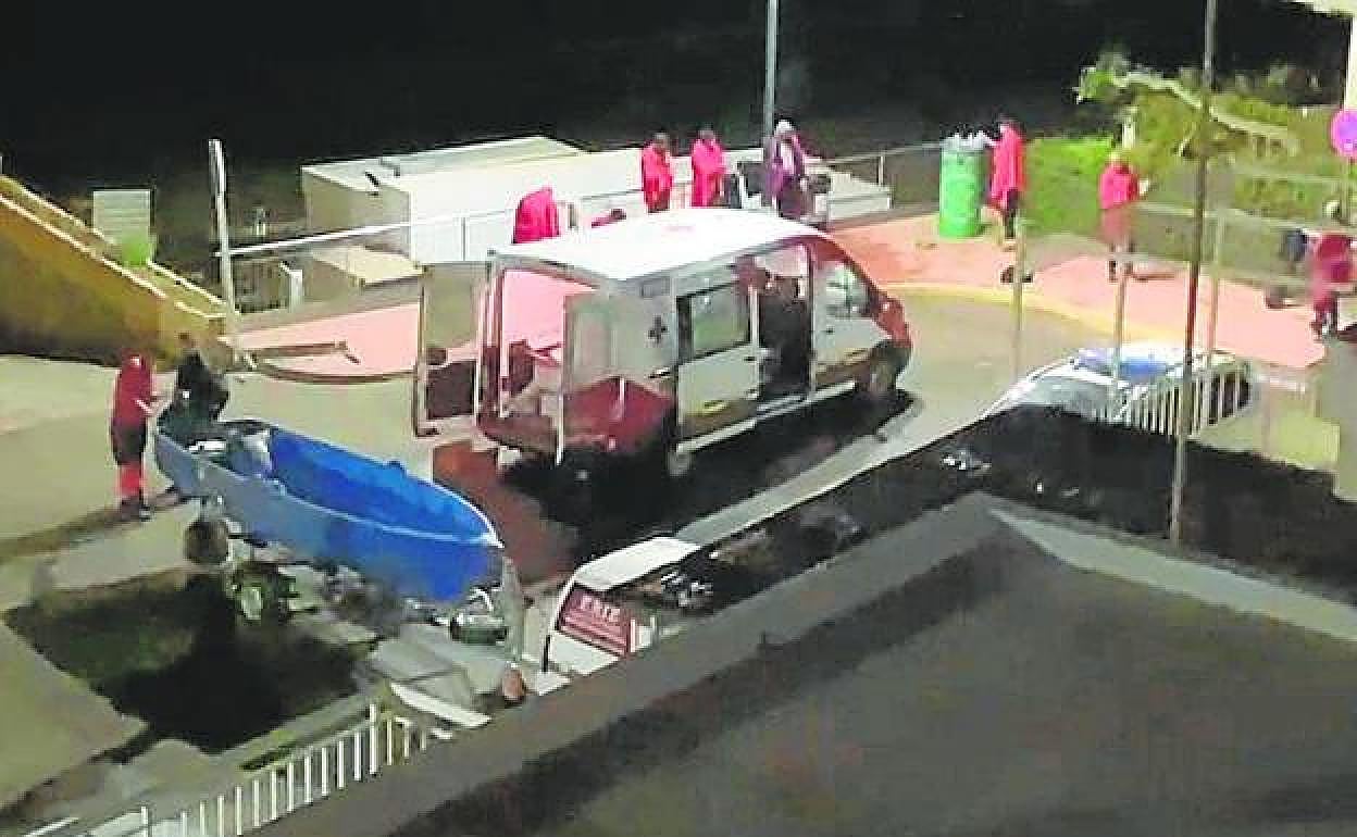 La barca localizada en Águilas este lunes, en primer plano, y sus ocupantes, con mantas, al fondo.