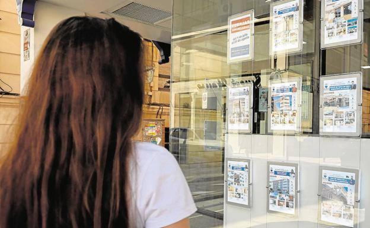 Una mujer observa las viviendas en alquiler de una inmobiliaria de Murcia, en una imagen de archivo. 