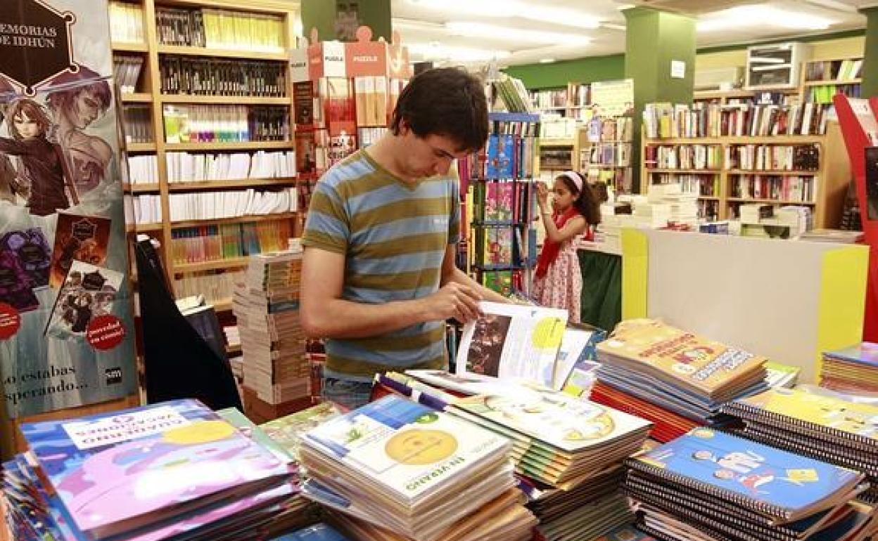 Un joven ojea un libro en una librería granadina. 