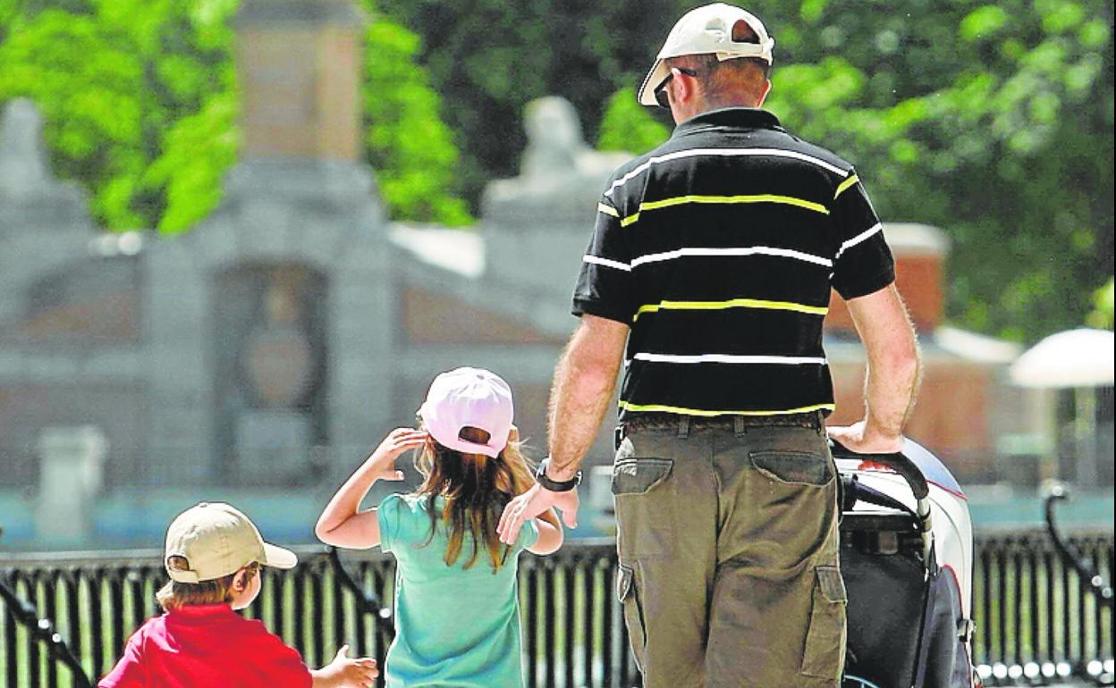 Una padre pasea con sus hijos, en una fotografía de archivo.