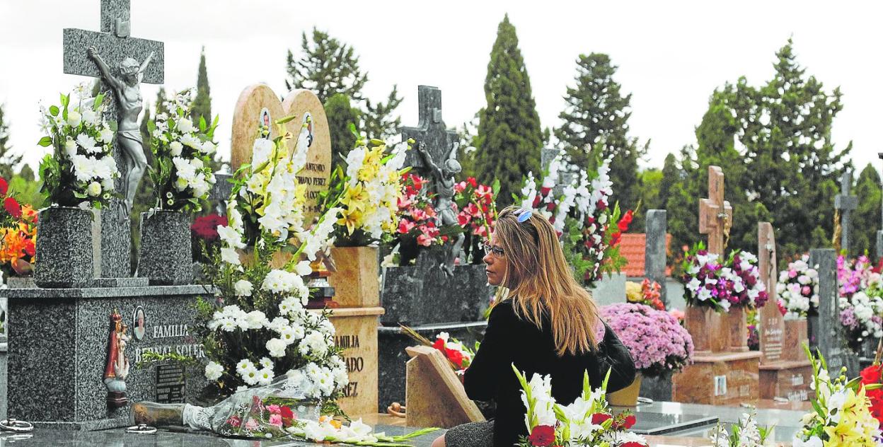 Una mujer visita una tumba, en una imagen de archivo. 