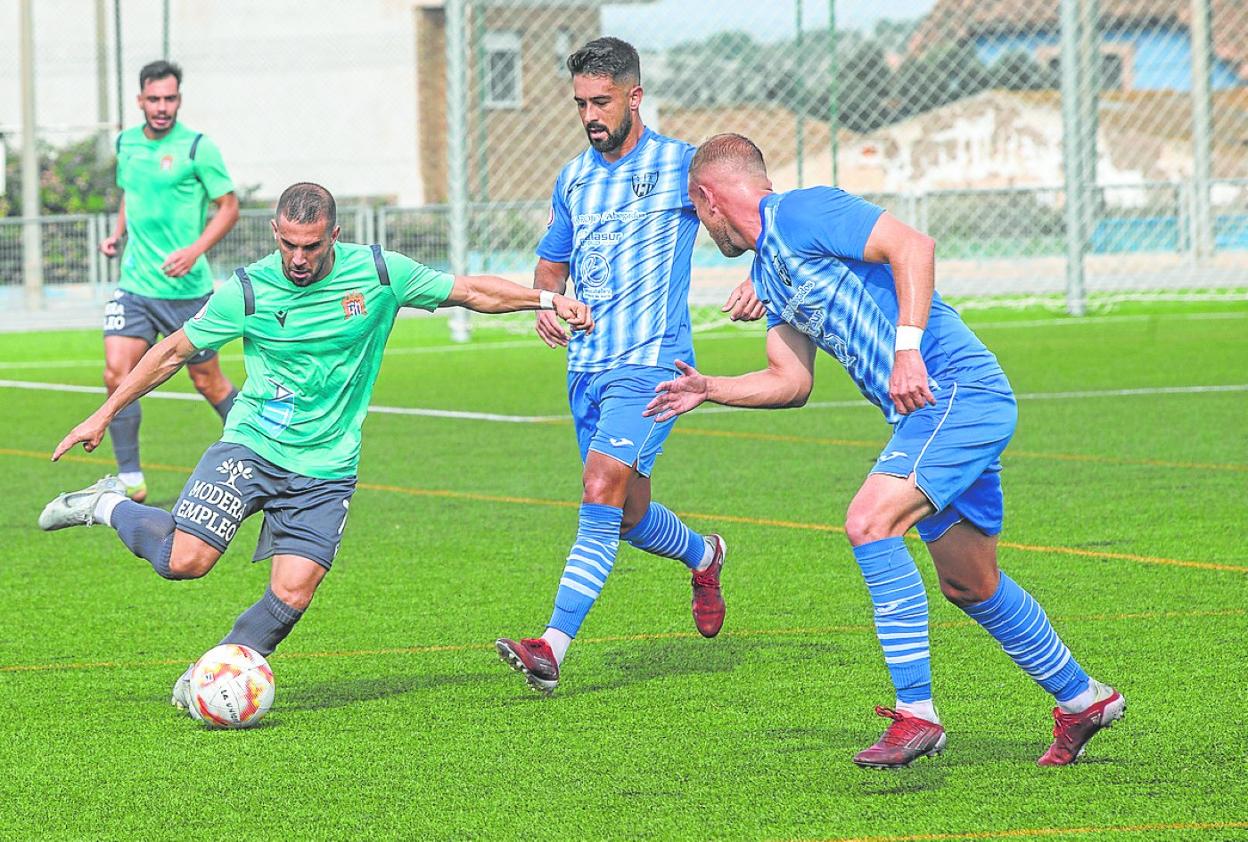El futbolista del Águilas Aitor Pons intenta irse dos rivales, ayer en La Unión. 