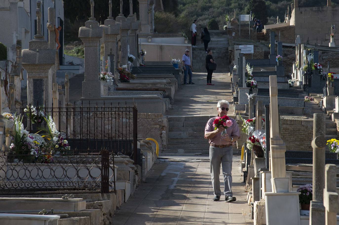 Un hombre porta un ramo de flores en el cementerio de Los Remedios, en Cartagena, este martes.