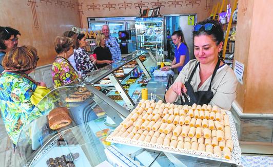 Una confitera muestra una bandeja de huesos de santo en la confitería Bonache de Murcia. 
