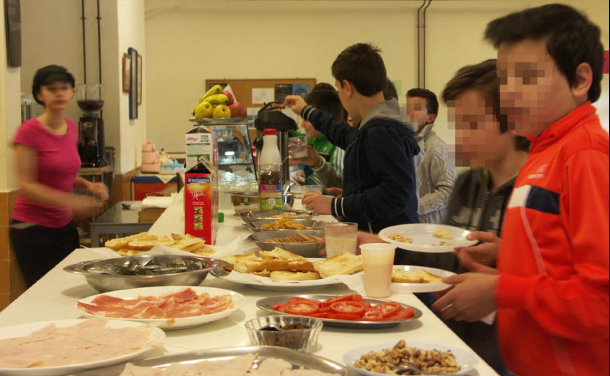 Estudiantes sirviéndose comida en la cantina de un instituto, en una imagen de archivo.