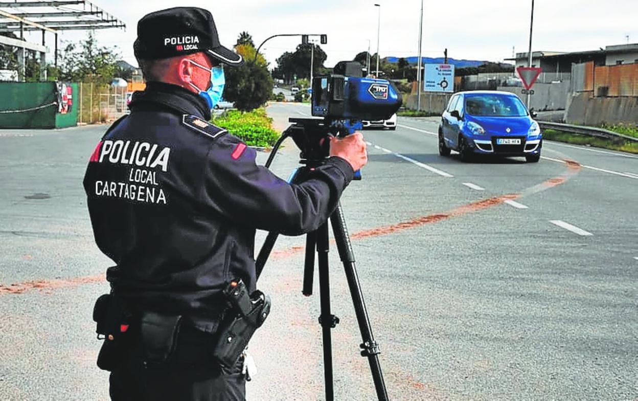 Un policía local, durante un control de tráfico con radar. 