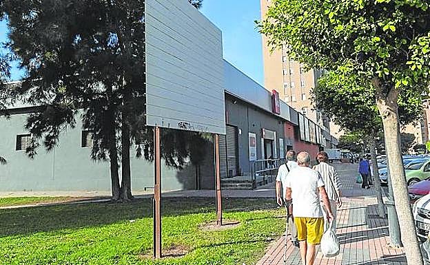 Imagen principal - Arriba: cartel del PlanE, que una década más tarde sigue en pie en la Avenida de Murcia. Izquierda: rejillas de la fuente ornamental sin uso del Parque de Los Juncos.. Derecha: un peatón que transita hacia Tentegorra pasa junto a la estructura del quiosco que lleva varios años en el jardín Antonete Gálvez.