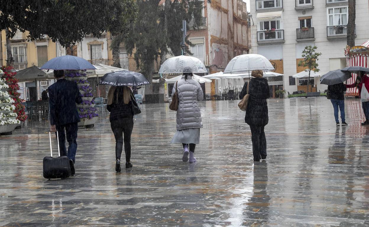Imagen de archivo de varias personas paseando por Cartagena mientras llueve.