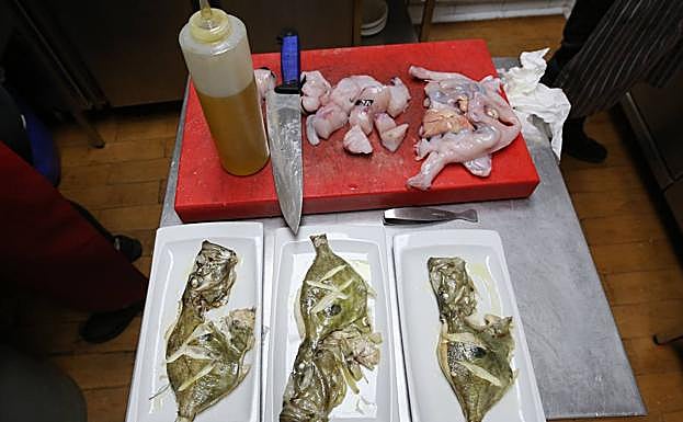 Confitados. Pescado troceado en la tabla y tres gallopedros emplatados y listos para salir a la sala.