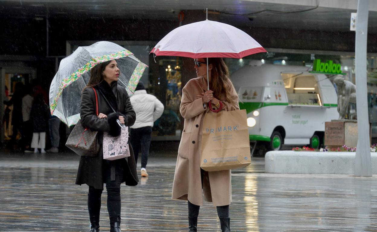 Dos chicas pasean bajo la lluvia en Murcia, en una imagen de archivo.