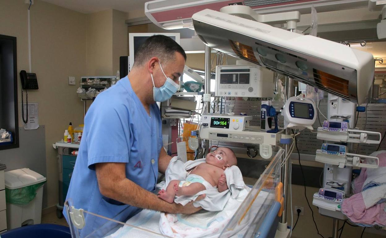 Un enfermero cuida de Julieta en la UCI neonatal de La Arrixaca
