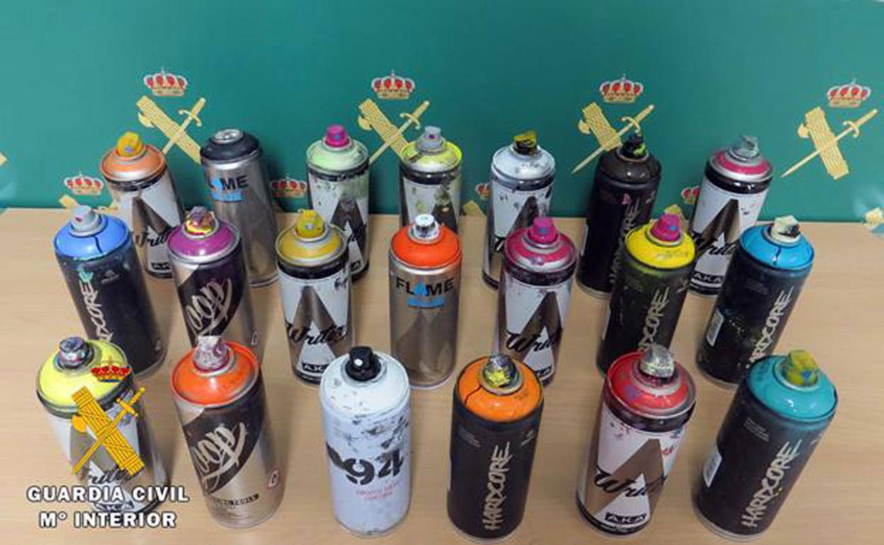 Botes de pintura incautados a los investigados.