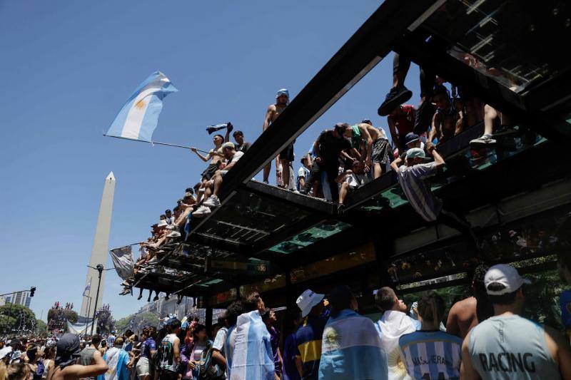 Hinchas enloquecidos se suben a las plataformas cercanas al obelisco para seguir la celebración.