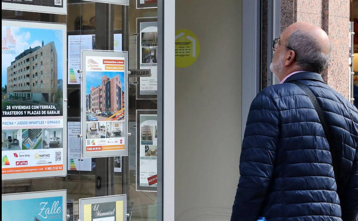 Un hombre estudia los anuncios de viviendas en venta. 