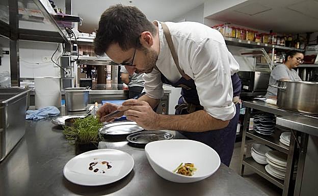 El chef selecciona brotes de hinojo para acompañar uno de sus platos. 