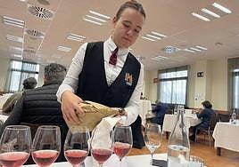Una camarera echa vino rosado en varias copas en el Certamen Anual de Calidad de Vinos de la D.O.P. de Bullas.