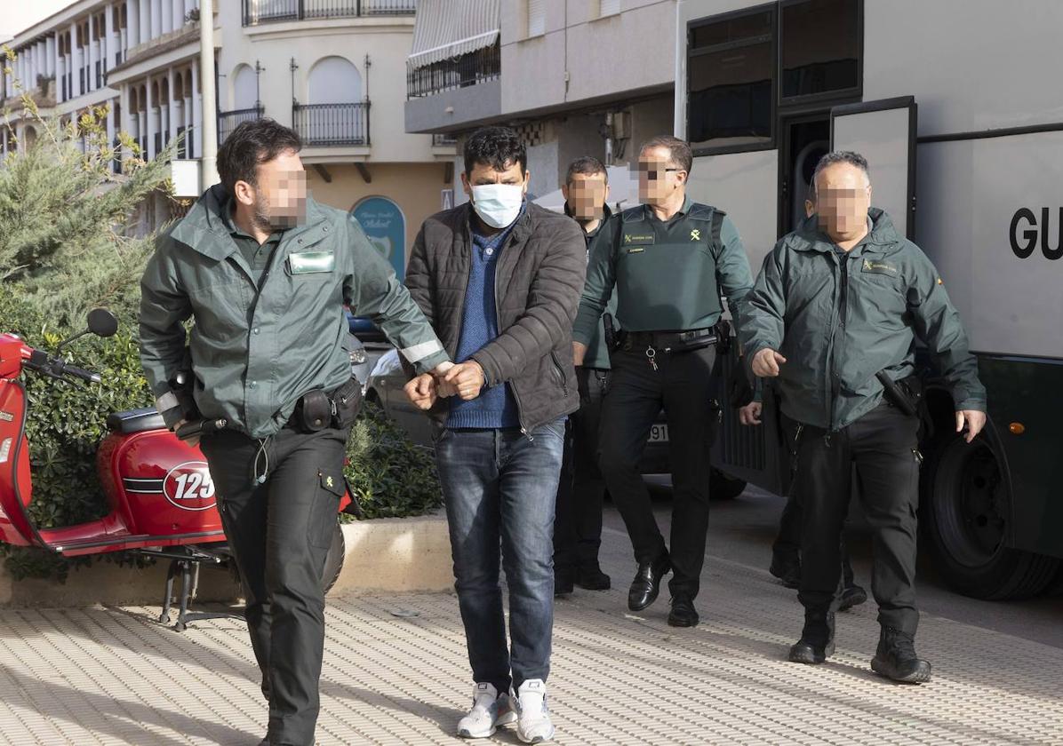 Agentes de la Guardia Civil trasladan a los juzgados a uno de los detenidos este viernes.