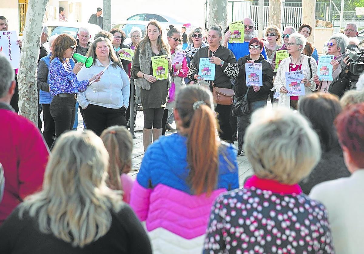 Los vecinos de Pozo Estrecho escuchan a la presidenta vecinal, Susana García, mientras habla por el megáfono.