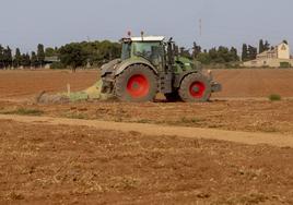 Imagen de archivo de un agricultor en su tractor mientras labra.