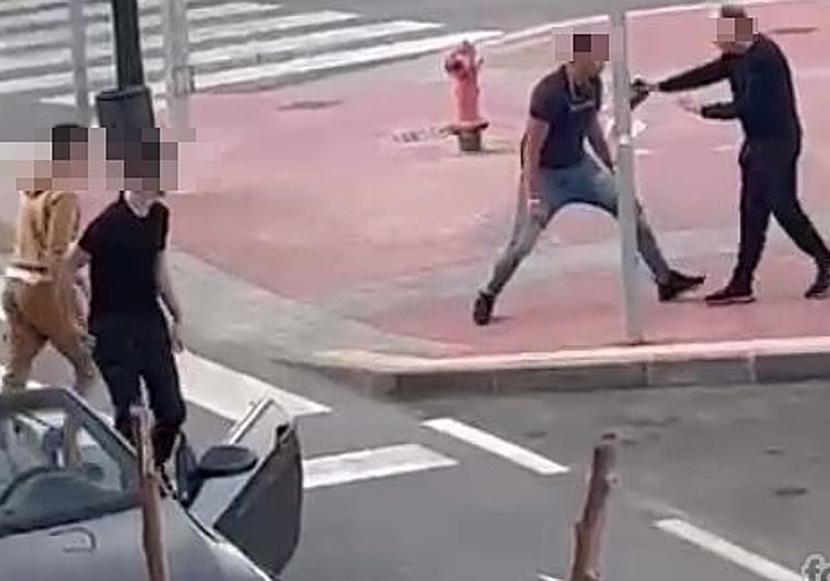 Uno de los ocupantes del vehículo hace el gesto de clavar un arma blanca al peatón.