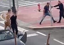 Uno de los ocupantes del vehículo hace el gesto de clavar un arma blanca al peatón.