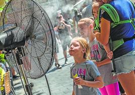 Una niña se refresca frente a un ventilador con nebulizador.