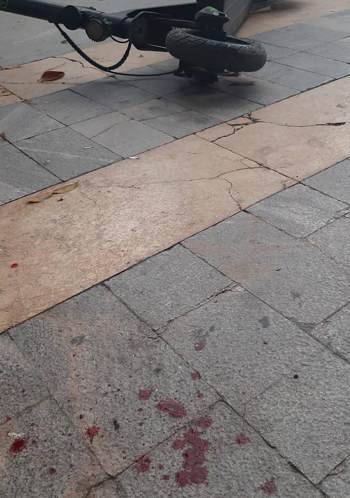 Restos de sangre en la acera tras el impacto del patinete.