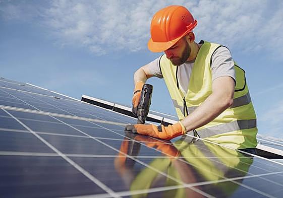 Un trabajador instala una placa solar.