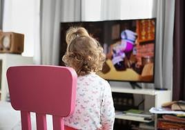 Una niña ve dibujos animados.