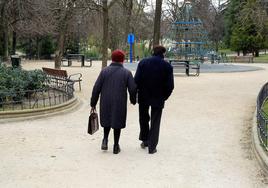 Imagen de una pareja dando un paseo por un parque madrileño.