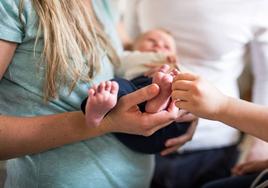 Una madre sostiene en brazos a su bebé.