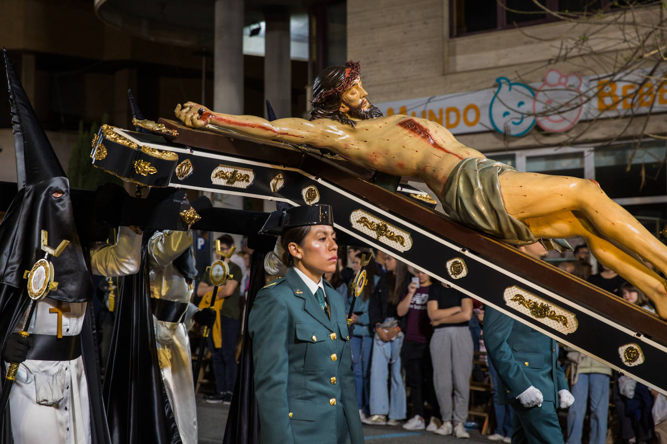Al Cristo lo acompañan una pareja de agentes de la Guardia Civil y cuatro cofrades con incensarios.