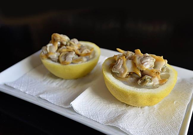 Berberechos sobre limón fresco recién cortado.