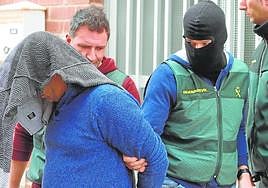 Agentes de la Guardia Civil trasladan a uno de los detenidos en la macrorredada desplegada el pasado marzo en Roldán.