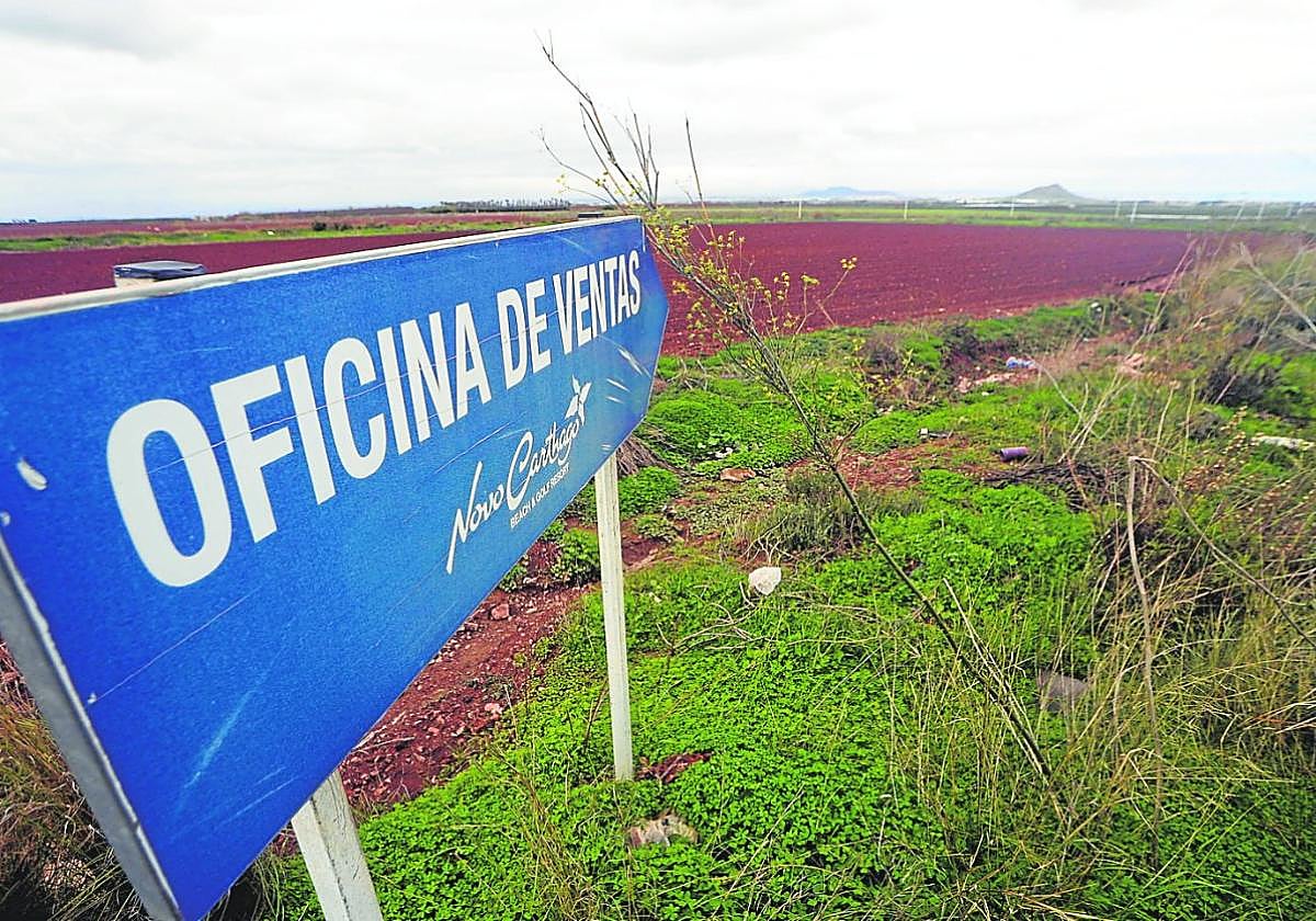 Un cartel señala la desmantelada oficina de ventas de Novo Carthago, con Lo Poyo en primer término y las islas del Mar Menor a lo lejos.