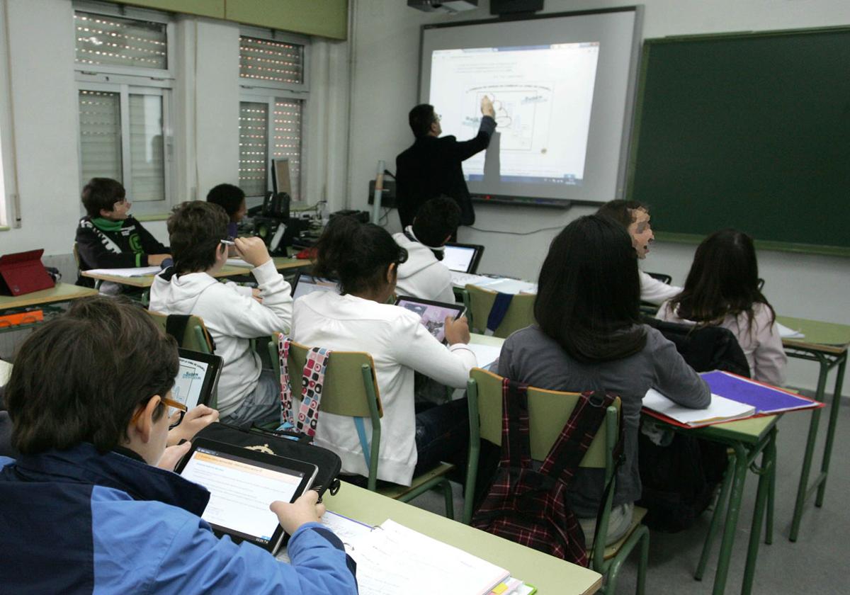 Un profesor imparte clase con una pizarra digital en una imagen de archivo.