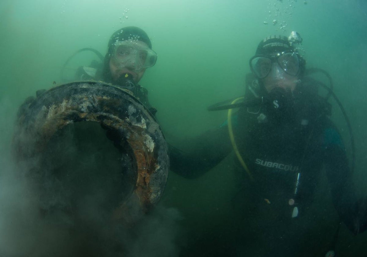 Dos integrantes de la Asociación Hippocampus recogen basura del fondo marino.