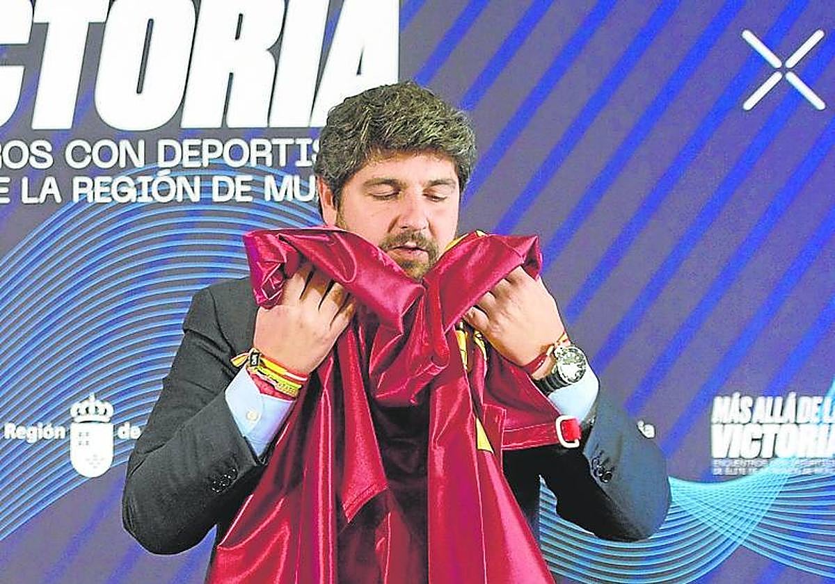 López Miras, ayer, con la bandera de la Región, en un acto con deportistas murcianos.