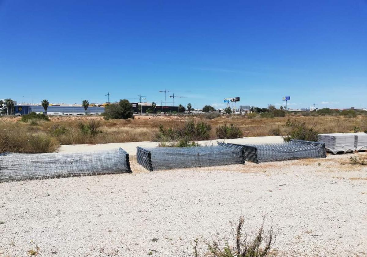 Secciones de valla apiladas en los terrenos de Cala Mosca.