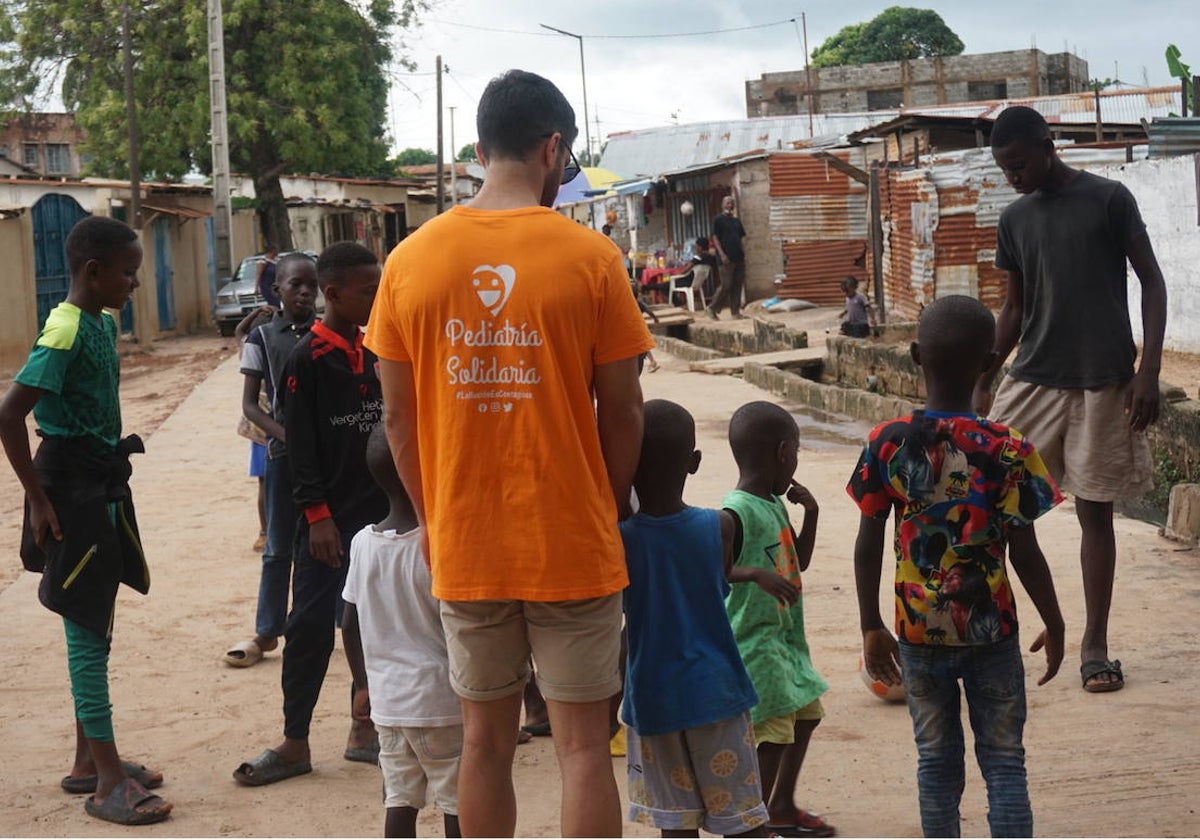 Uno de los voluntarios de Pediatría Solidaria juega con un grupo de niños en Faji Kunda, en Gambia, el pasado mes de julio.