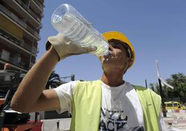 Un trabajador de la construcción se refresca ante la subida de las temperaturas.