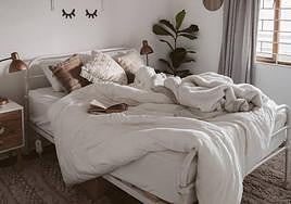 Imagen de una cama con edredón y mantas.