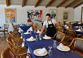 El personal de sala prepara las mesas en el comedor.